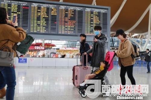 旅客帶著孩子前往辦票柜臺(tái)辦理登機(jī)手續(xù)?！∫罅⑶?攝