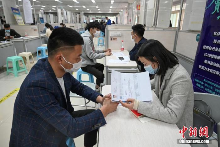 4月14日，招聘者在查看求職者簡歷。<a target='_blank'  data-cke-saved- >中新社</a>記者 王剛 攝