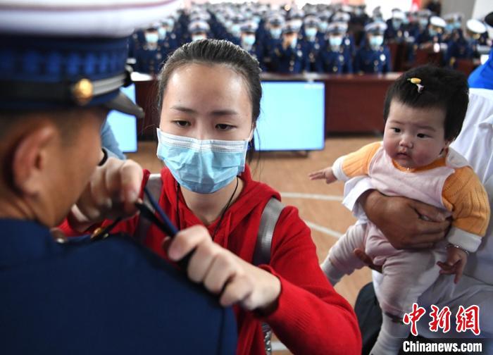新消防員楊振的妻子彭莉與女兒現(xiàn)場(chǎng)見證丈夫加入“火焰藍(lán)”的神圣時(shí)刻?！⒅铱?攝