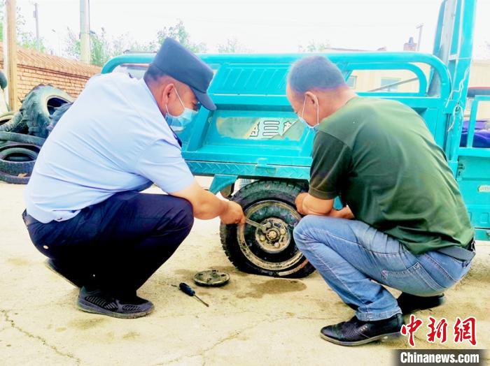 賽旦與民警共同維修三輪摩托車?！∫懒窘?攝