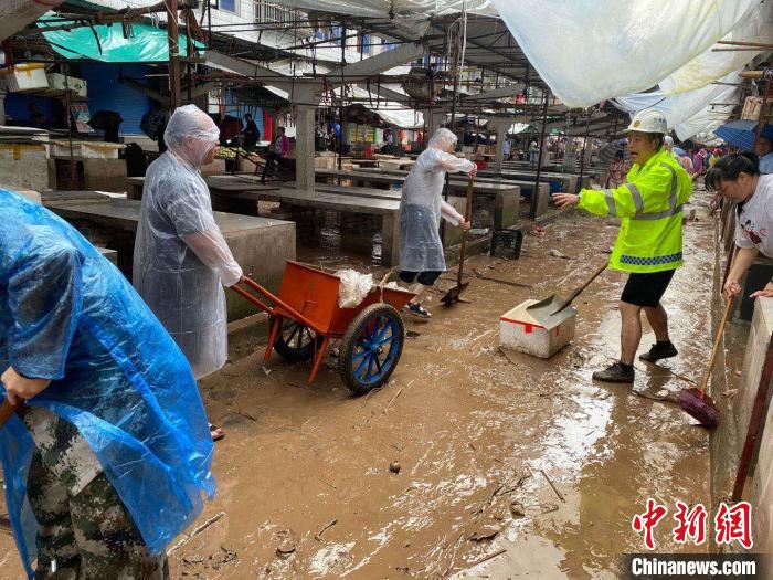 圖為7月26日，暴雨引發(fā)的洪水過境后，重慶萬州區(qū)分水鎮(zhèn)政府干部職工及志愿者清掃淤泥和垃圾?！　≈貞c萬州區(qū)委宣傳部供圖 攝